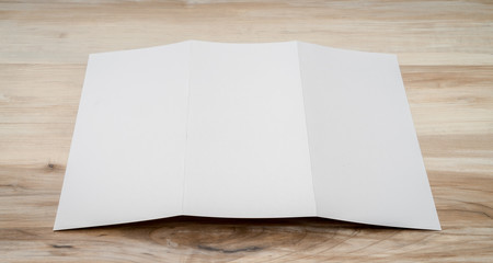 Trifold white template paper on wood texture..