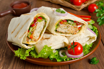Fresh tortilla wraps with kebab and fresh vegetables on plate
