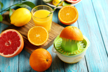 Citrus fruits with juicer on a blue wooden table