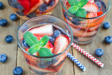 Cocktail with strawberry and blueberry on a wooden table, horizontal