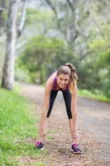 Young woman bending on footpath