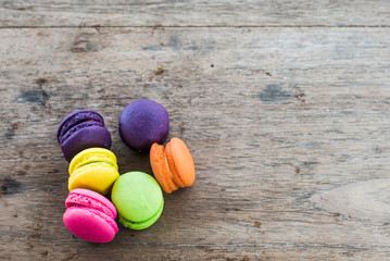 french sweet delicacy, colourful macaroons variety with wood Background