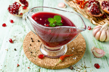 Fresh pomegranate sauce for meat on a wooden table