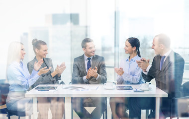 business team with laptop clapping hands