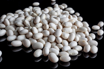 Scattered white beans on black background