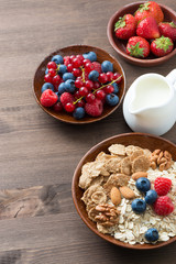 oatmeal and muesli in a bowl, fresh berries and milk 