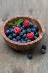 wooden bowl with fresh blueberries and raspberries
