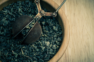 green tea, dried leaves with filter, on wooden background, vinta