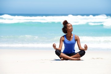 Fototapeta na wymiar Healthy young yoga woman meditating at the beach