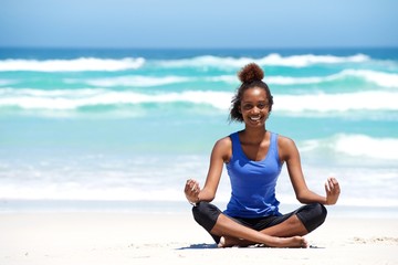 Fototapeta na wymiar Smiling young african woman in yoga pose