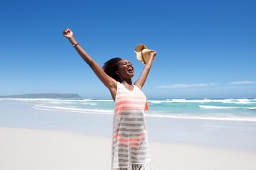 Fototapeta na wymiar Laughing young woman standing on beach