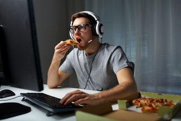 man in headset playing computer video game at home