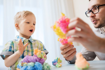 father and son playing with ball clay at home