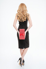 Back view of woman with long curly hair holding present