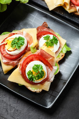 Delicious sandwich with prosciutto ham, cheese, tomato and egg