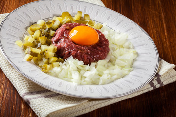 Steak tartare with egg yolk, onions and pickles