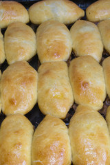 The metal baking sheet with rosy baked pies