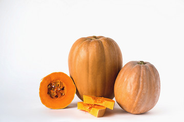 Two whole pumpkin and sliced on a white background, vegetarian food, organic, orange, health