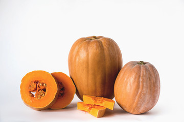 Two whole pumpkin and sliced on a white background, vegetarian food, organic, orange, health