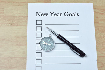 Concept : pen and compass on paper with new year goals word on w