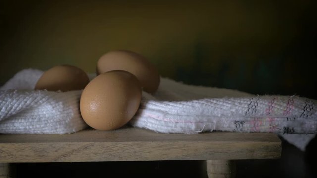Continuous dolly shot of eggs on wood & clothe resembling still life