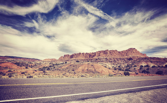 Vintage old film stylized picture of a scenic desert road.