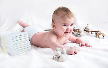 Baby in diaper on a white background with a branch of cotton - 107779737