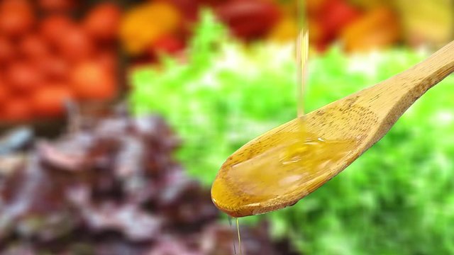 Olive oil that drips on a wooden spoon