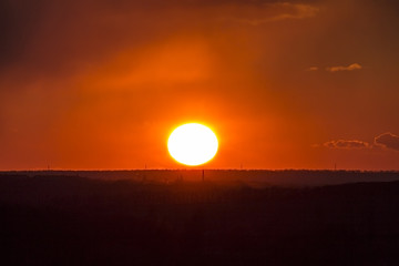 Sunset or sunrise sun and clouds, red. Bright contrast picture of nature.