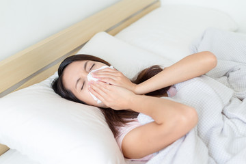 Obraz na płótnie Canvas Woman sneeze on bed