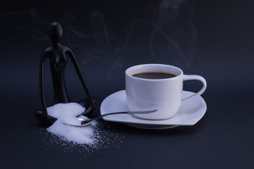 Cup of coffee, sugar and meditating statue