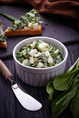 Bruschetta with ramson salad on slate background