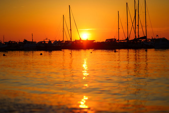 Yachts and boats at Adriatic sea bay at sunset in golden and pink tones in Salermo