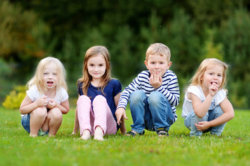 Naklejka na ściany i meble Four adorable little kids outdoors