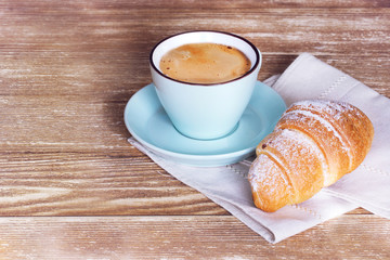 Coffee croissant on wooden background empty copy space.