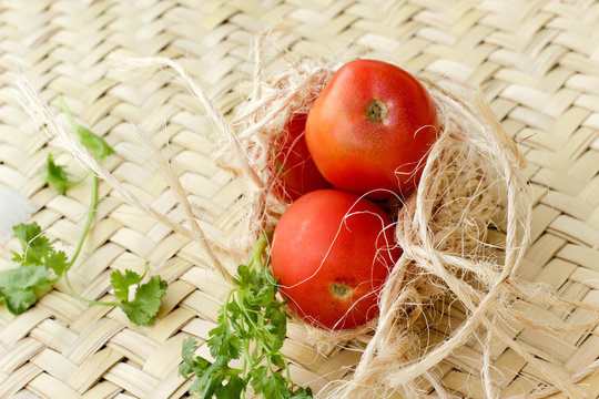 Tomates en un nido de mecate y un petate