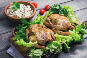 Wild and long grain white rice in a wooden bowl, two baked chick