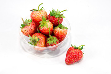 A group of strawberry in a bowl and isolated one on white backgr