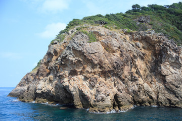 Fototapeta na wymiar rough stone island in blue sea