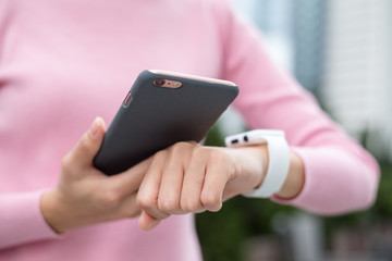 Woman using smart watch and connecting with cellphone