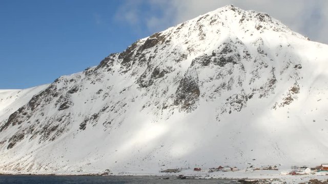 Snow covered mountains at a Fjord in the Lofoten islands region in Norway during winter.