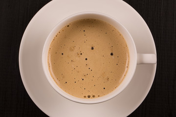 Cappuccino with cinnamon in a white cup. Coffee on Black Wooden Table