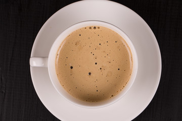 Cappuccino with cinnamon in a white cup. Coffee on Black Wooden Table