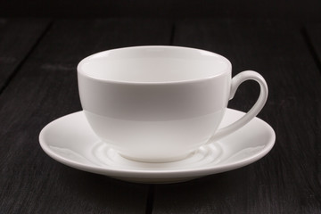 Obraz premium Cappuccino with cinnamon in a white cup. Coffee on Black Wooden Table