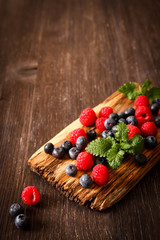 blueberries and raspberries on a wooden board background wood da