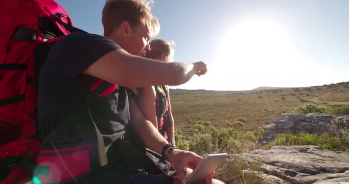 Hiker showing girl friend map on smartphone during outdoor activity