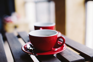 Two red cups on wooden plank table