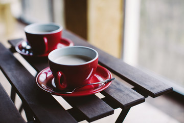Two red cups on wooden plank table