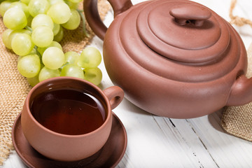 Cluster of grapes and clay cup with tea