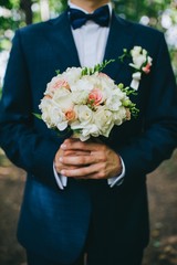 The groom is holding a wedding bouquet